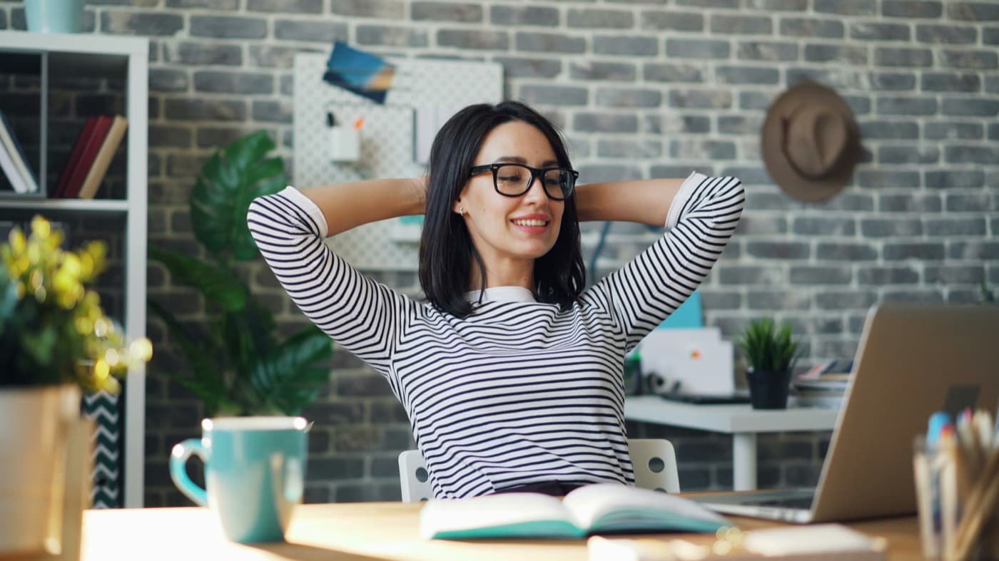 Relaxed businesswoman at her laptop — everything answered quickly